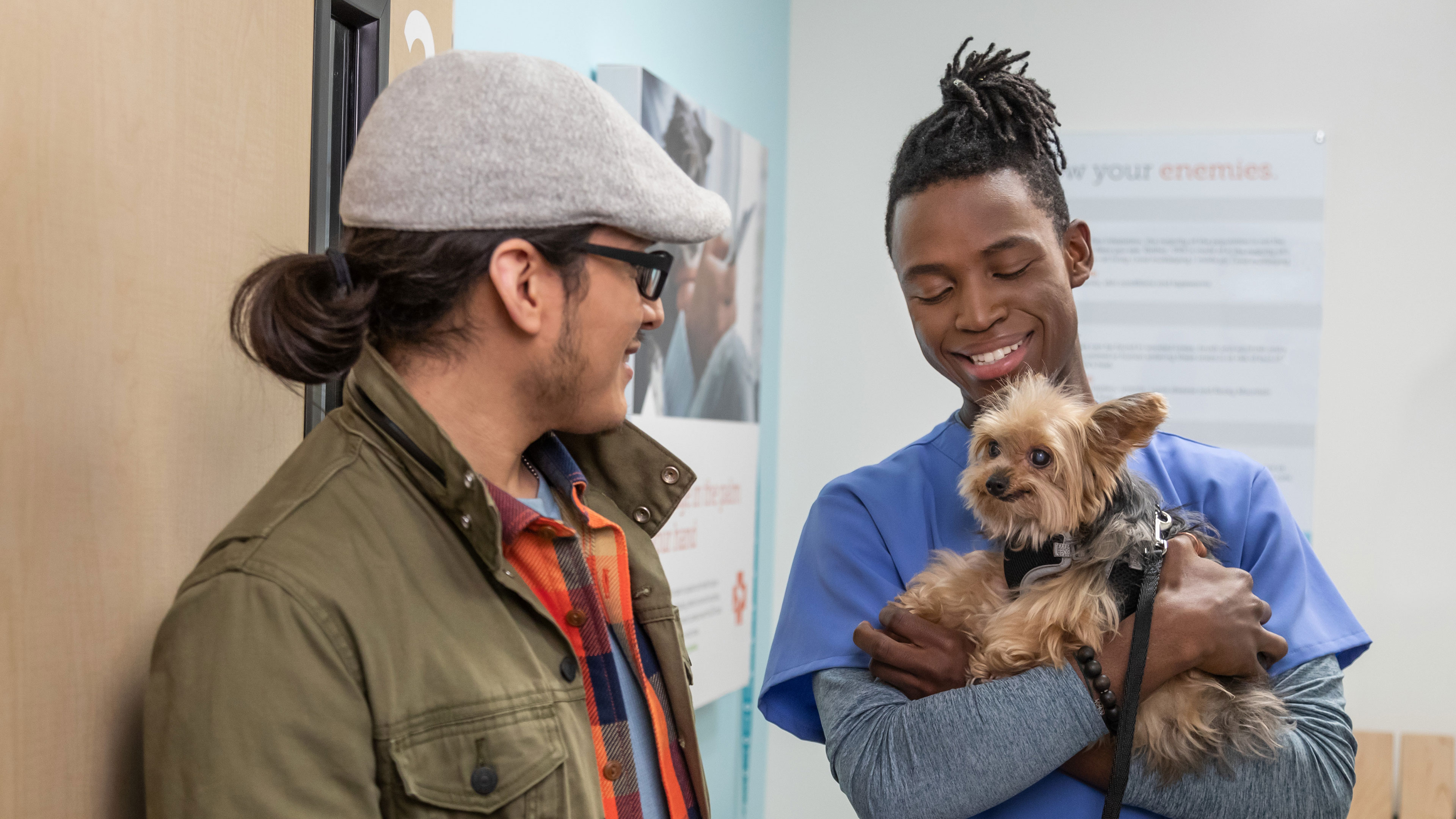 Owner looking at small dog being held at pet hospital 