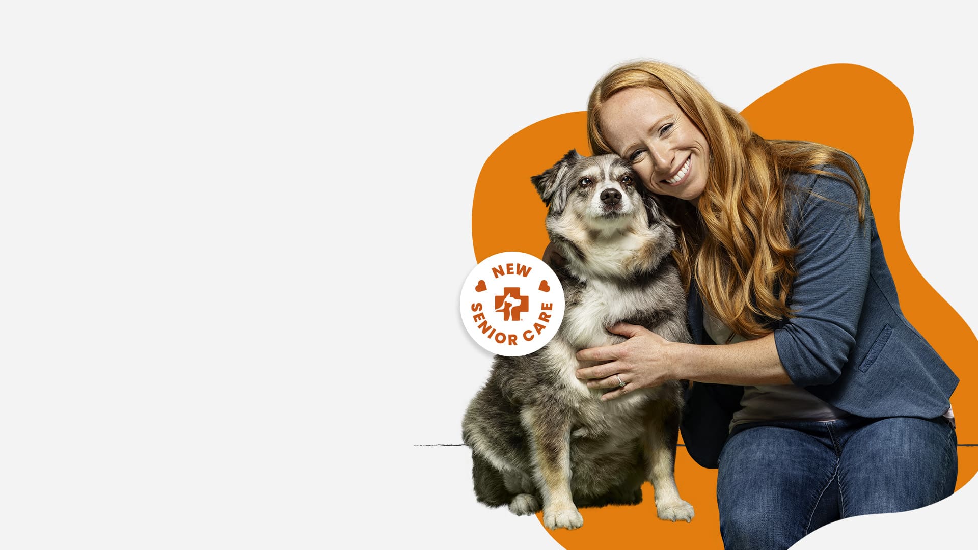 Image of a woman sitting down hugging an elder dog